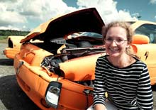 Camilla Palmertz foran en af de orange Volvo'er, hun har crashet for at forbedre de ufødte børns sikkerhed.
